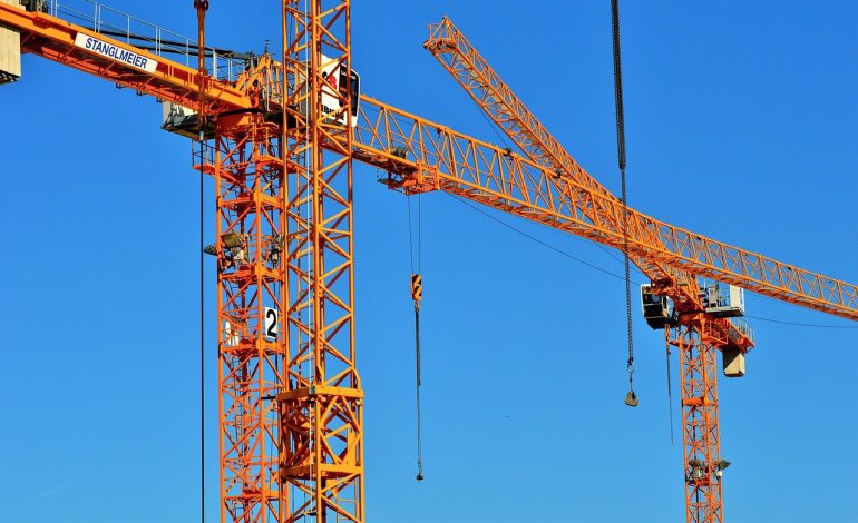Certified crane inspector examining a mobile crane on a construction site